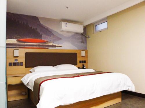a bedroom with a large bed and a painting on the wall at Thank Inn Plus Hotel Shanxi Jinzhong Yuci District Yingbin West Street Yinhaixinyue in Jinzhong