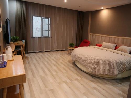 a bedroom with a large bed and a table and chairs at Up And In Hubei Suizhou Zengdu Qinghe Road Shengshihuating in Suizhou