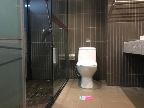 a bathroom with a toilet and a shower stall at Thank Inn Plus Hotel Hubei Jingzhou City Jingzhou District Railway Station in Jingzhou