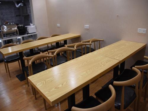 a row of wooden tables and chairs in a room at Thank Inn Plus Hotel Chongqing Wanzhou District Pedestrian Street in Wanxian