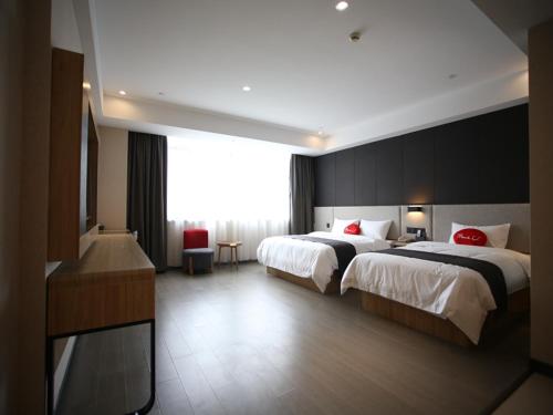 a hotel room with two beds and a television at Thank Inn Plus Jiangsu Zhenjiang Jiangkou District Hongdou Square in Zhenjiang