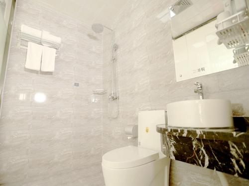 a white bathroom with a toilet and a sink at Thank Inn Plus Hotel Shandong Zaozhuang Tengzhou Parallel Road Qinghe Shangcheng Community in Zaozhuang