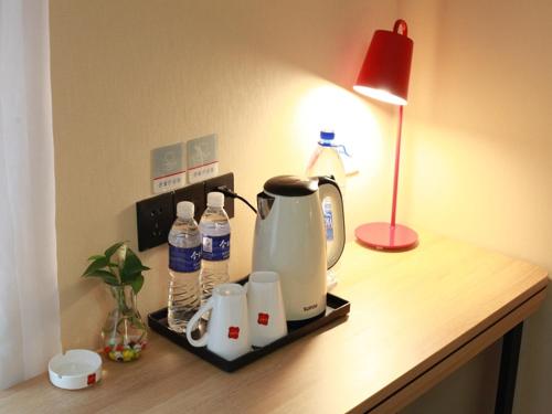 a table with a coffee maker and bottles of water on it at Thank Inn Plus Hotel Shandong Jining Qufu City Sankong Tourist Center in Jining