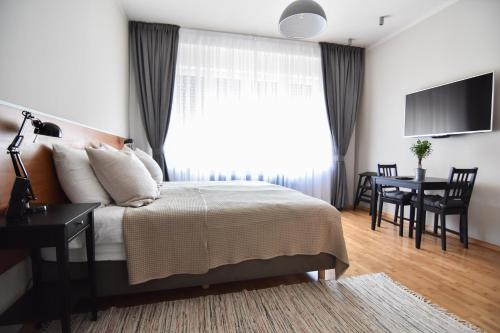 a bedroom with a bed and a table and a window at Karlo Main Square Apartments in Zagreb