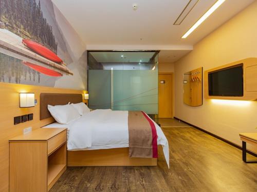 a hotel room with a bed and a tv at Thank Inn Plus Hotel Sichuan Chengdu Jianyang Dongcheng Huafu in Chengdu