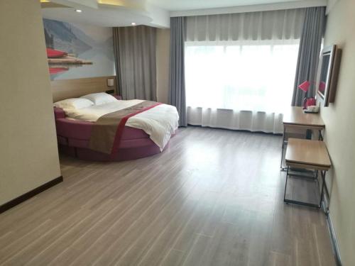 a hotel room with a bed and a large window at Thank Inn Plus Hotel Henan Shangqiu Suiyang District Shenhuo Avenue South in Shangqiu