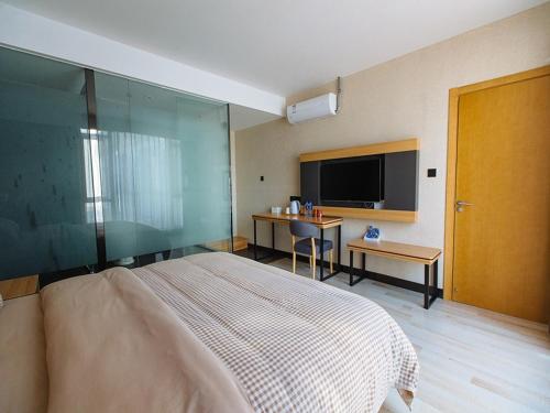 a bedroom with a large bed and a flat screen tv at Up And In Anhui Wuhu Anhui University of Engineering in Wuhu