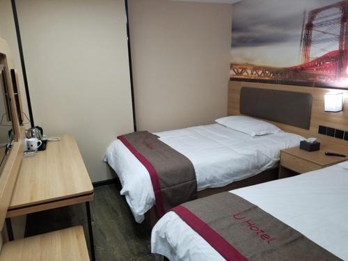 een hotelkamer met 2 bedden en een schilderij van een brug bij Thank Inn Plus Hotel Jiangsu Suzhou Kunshan Zhangfu in Suzhou