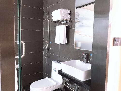 y baño con aseo, lavabo y espejo. en Thank Inn Plus Hotel Shandong Weihai Rongcheng City Chengshan Avenue Rt-mart en Weihai