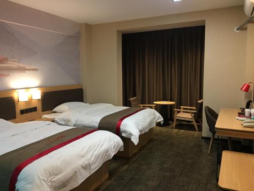 a hotel room with two beds and a desk at Thank Inn Plus Hotel Guangxi Liuzhou Luzhai County Bus Station in Liuzhou
