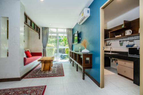 a kitchen with blue walls and a red couch at Kata Tranquil Villa - SHA Plus in Karon Beach
