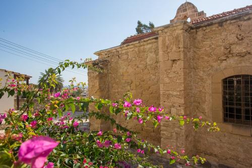 a stone building with pink flowers in front of it at Penthouse Duplex overlooking the Mediterranean in Larnaka