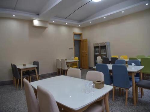 ein Zimmer mit Tischen und Stühlen in einem Klassenzimmer in der Unterkunft Thank Inn Plus Hotel Henan Luoyang Xinan Luoxin Industrial Cluster in Luoyang