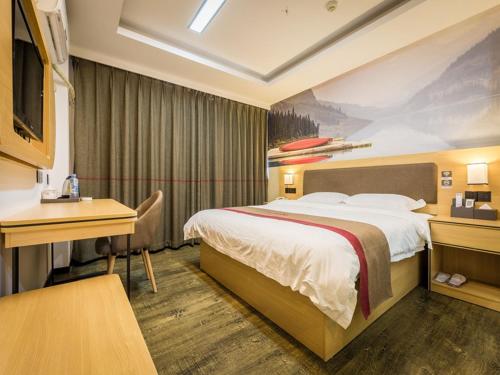 a hotel room with a bed and a desk at Thank Inn Plus Hotel Jiangxi Ganzhou Nankang District East Bus station in Ganzhou