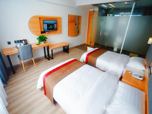 蘇州市にあるThank Inn Plus Hotel Jiangsu Suzhou Dushu Lake Dongxing Roadのベッド2台とデスクが備わるホテルルームです。