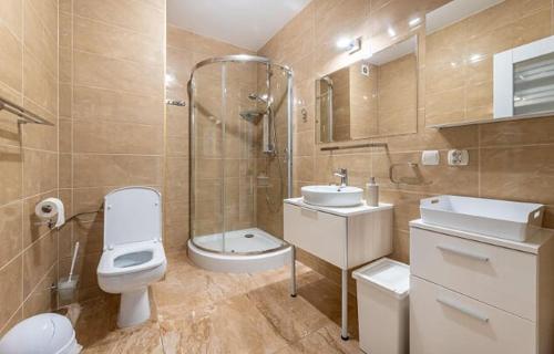 y baño con aseo, lavabo y ducha. en Apartament przy Deptaku, en Ustrzyki Dolne