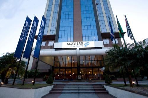 a large building with flags in front of it at Airport Business Flat Guarulhos - São Paulo in Guarulhos