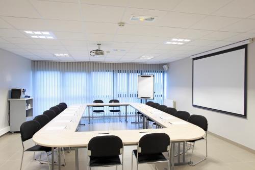 a conference room with a large table and chairs at The Originals City, L'Haut' Aile, Coquelles-Calais Tunnel s/Manche L'HAUTAILE in Coquelles