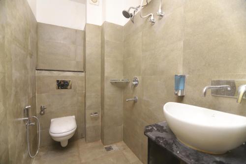 a bathroom with a white sink and a toilet at Hotel Shiva Yog Sthal in Rishīkesh