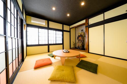 Pokój ze stołem i żółtym dywanem w obiekcie enjoy Mt.Fuji A w mieście Fujiyoshida