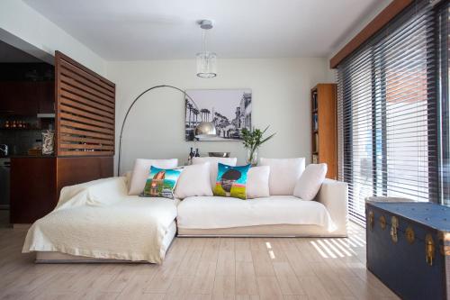 a living room with a white couch in a room at Penthouse Duplex overlooking the Mediterranean in Larnaka