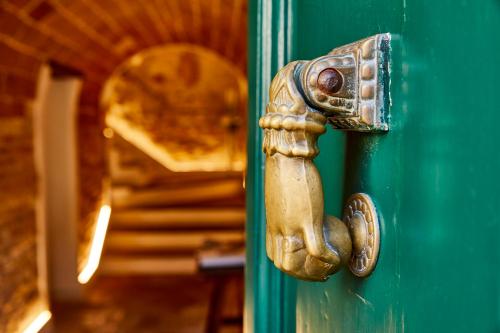 a golden door knob on a green door at AleMar Sirolo in Sirolo