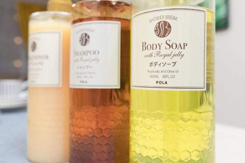 three bottles of baby soap and a bottle of wine at Ostay Shin-Osaka Hotel Apartment in Osaka