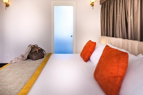 a bedroom with a large bed with orange pillows at Villa Zaccardi in Rome