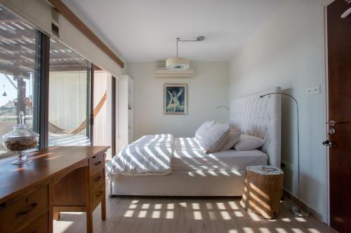 a bedroom with a bed and a desk and a window at Penthouse Duplex overlooking the Mediterranean in Larnaka