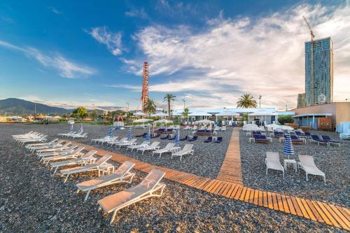 - une rangée de chaises longues sur une plage dans l'établissement Apartment Gamarjoba Batumi, à Batoumi