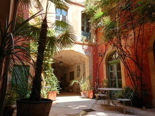 a courtyard with a table and chairs in a building at Rue du Château in Tarascon