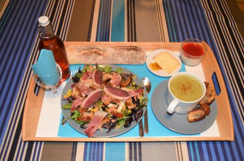 a tray with a plate of food with a salad and a drink at Maison d'hôtes MIRADOUR in Labenne