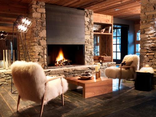 a living room filled with furniture and a fireplace at M de Megève in Megève