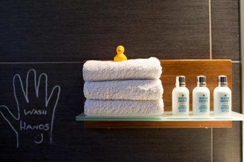 a stack of towels on a shelf with a rubber duck on top at Penthouse Duplex overlooking the Mediterranean in Larnaka