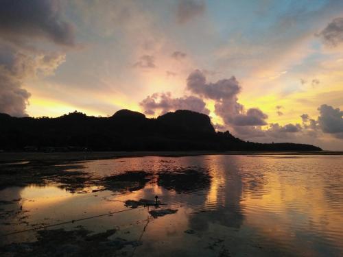 a sunset over a body of water with clouds at The Tropical Koh Mook in Koh Mook