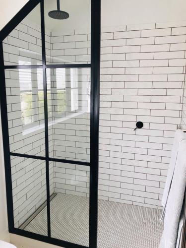 a shower with a glass door in a bathroom at African Flame Apartment in Knysna