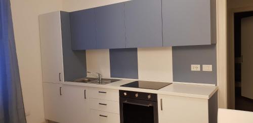 a kitchen with white cabinets and a sink and a stove at Le Casette Di Osvaldo in Lecco