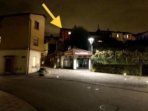 a building on a street at night with a yellow arrow at Comano Lugano Ticino - B&B Walterina in Comano