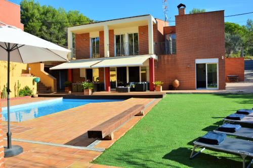 a house with a pool and a yard with chairs at Villa Sitges Maria Sunny Oriented SW AC Confortable High Quality 5 star guest coments in Olivella