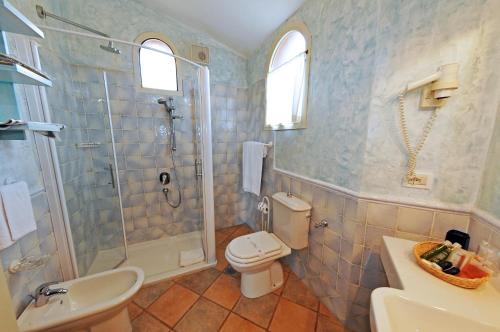 a bathroom with a shower and a toilet and a sink at Grand Hotel In Porto Cervo in Porto Cervo