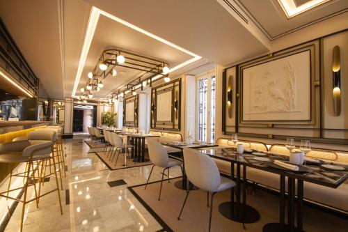 a restaurant with tables and chairs in a room at MYR Palacio Vallier in Valencia