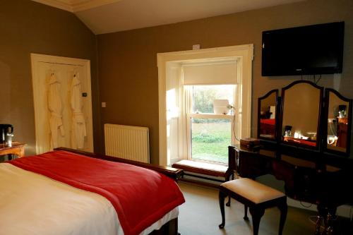 um quarto com uma cama e uma janela em Crookedstone House em Antrim