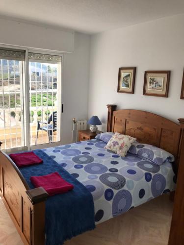 a bedroom with a bed with a blue and gray comforter at KaSandra in Rojales