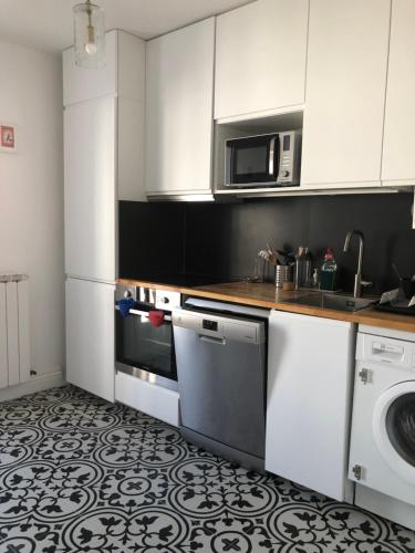 a kitchen with a stove and a dishwasher at Appart 2 pièces avec parking QUARTIER DU LAC in Saint-Jean-de-Luz
