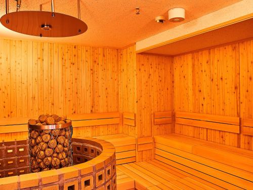 a sauna with a large vase of logs in it at Anshin Oyado Woman&Man Nagoya Sakae in Nagoya