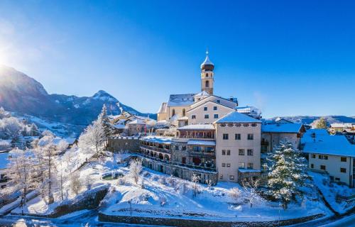 a building on top of a mountain in the snow at Romantik Hotel Turm in Völs am Schlern