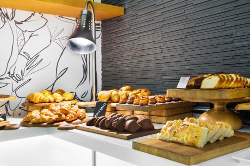 a table with different types of bread and pastries at Mercure Sohar in Sohar