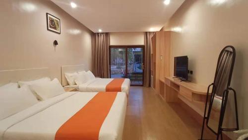 una camera d'albergo con due letti e una televisione di Camotes Ocean Heaven Resort a Camotes Islands