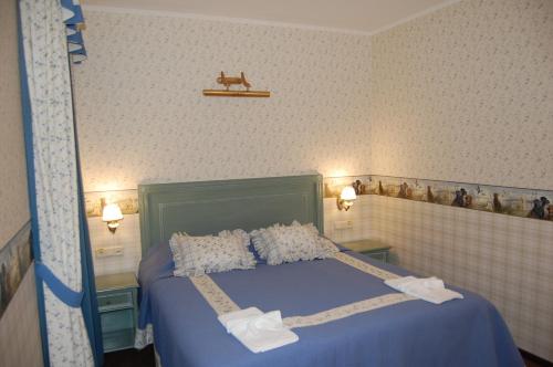 a bedroom with a bed with blue sheets and pillows at Готель Баварія in Poltava
