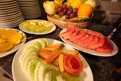 a table with plates of fruits and vegetables on plates at After Hours Residence in Dhaka